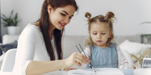 Tutor with pupil. Little girl studying. Private lesson. Mother helps her daughter.